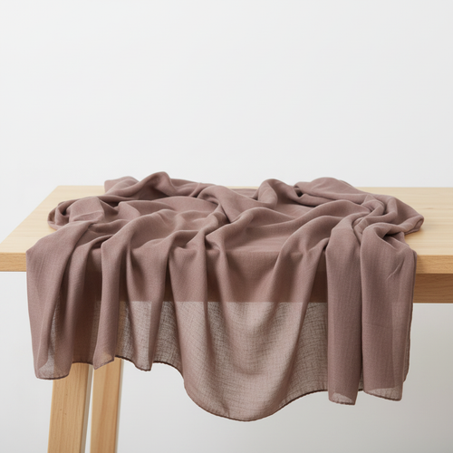 Brown plain modal scarf draped on wooden table